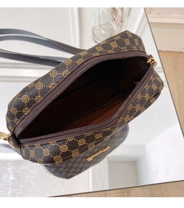 Detail view of the open crossbody camera bag with clover pattern and gold hardware