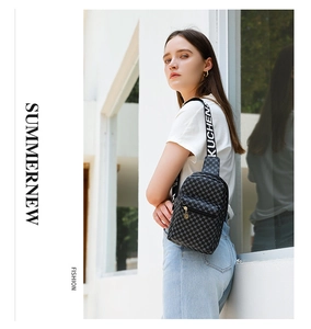 Detail of grey patterned chest bag featuring a KUCHEN lettered wide shoulder strap