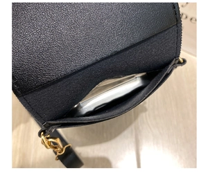 Close-up of black lychee grain leather phone bag showing interior space for smartphone