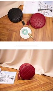 Detail of round quilted shoulder bag with leather tassel and gold chain strap in red and black