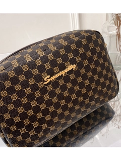 Close-up of brown clover print leather bag with gold metal logo and zipper detail