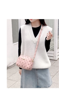Detailed look at the pink crossbody camera bag featuring floral pattern and adjustable strap