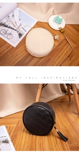 Detail of round quilted shoulder bags with tassels and gold chain straps in cream and black