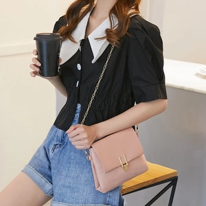 Pink crocodile pattern chain shoulder bag with gold clasp shown on a fashion model