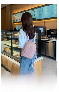 Mini sac à dos rose matelassé avec surpiqûres losanges dans un cadre de café décontracté