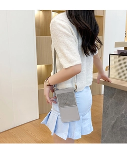 Detailed close-up of grey small vertical crossbody phone bag with laser cut floral patterns