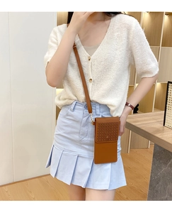 Detail view of brown PU leather crossbody phone bag with geometric hollow out pattern