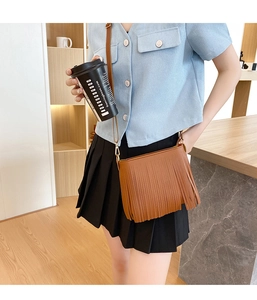 Borsa a tracolla marrone con frange da donna in una scena di stile di vita moda