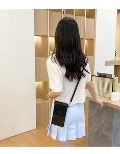 Close-up of a black vertical touchscreen phone bag featuring a geometric hollow pattern