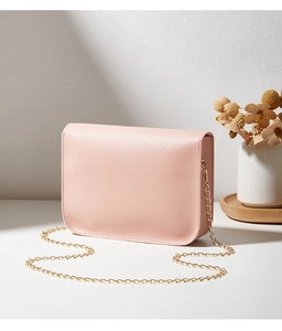 Détail du sac bandoulière en similicuir rose avec chaîne dorée et fini mat élégant