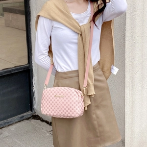 Pink crossbody camera bag with geometric pattern and adjustable textile strap