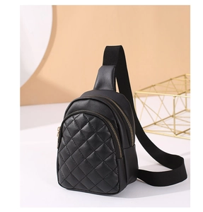 Detail of black quilted mini chest bag showing dual zipper closure and premium PU texture