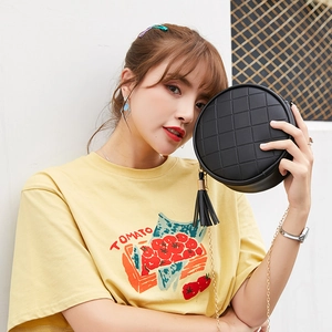 Quilted round PU leather crossbody bag with tassel and gold chain strap on model