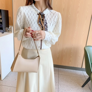 Women's chic beige leather shoulder bag paired with white crochet hollow long sleeve top
