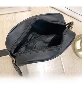 Macro view of the spacious black crossbody bag interior with zipper and metal hardware