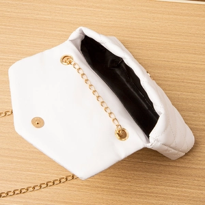 White quilted flap bag with gold chain strap and magnetic closure on wooden background