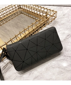 Detail of black geometric panel wallet with textured pattern and matching hand strap