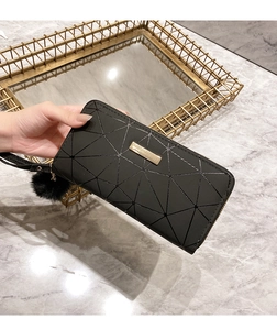 Detailed view of women's long zip wallet featuring black geometric quilted faux leather