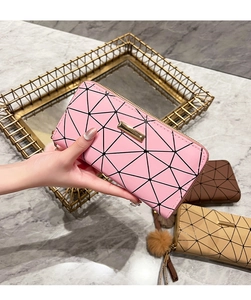 Detailed view of women's long wallet with geometric diamond pattern and fur ball charm