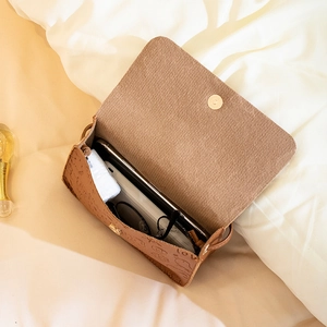 Brown embossed square crossbody bag with chain strap showing internal storage capacity