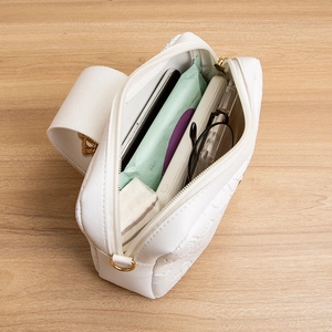 Sac bandoulière blanc matelassé montrant sa capacité intérieure pour téléphone