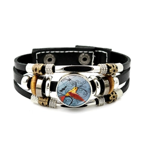Close-up of a hummingbird glass cabochon on a multi-layer woven leather punk bracelet