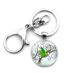 Detailed macro view of colorful hummingbird glass pendant with metal lobster clasp keyring