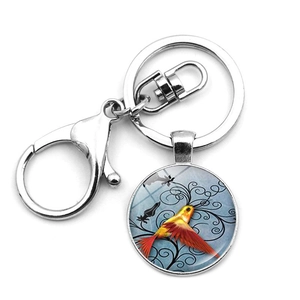 Close-up of hummingbird art pendant with silver lobster clasp and metal keyring