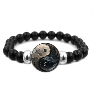 Macro detail of elastic beaded bracelet featuring artistic Yin Yang pendant and dark beads