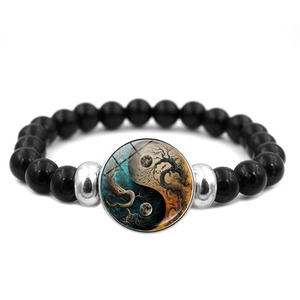 Close-up of Yin Yang glass charm on black beaded bracelet with starry moon pattern