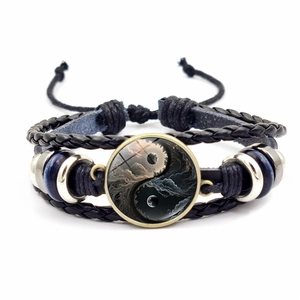 Gros plan détaillé du bracelet en cuir tressé Yin Yang avec perle de verre et accents