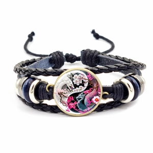 Détail du bracelet en cuir tressé avec cabochon dragon Yin Yang et perles bleues