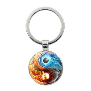 Macro view of Yin Yang keychain featuring creative fire and water art under glass dome
