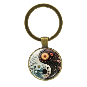 Detail of Yin Yang Tai Chi pendant keychain with floral motifs and bronze alloy finish