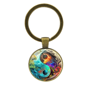 Detail of bronze Yin Yang keychain with artistic nature scene and floral motifs