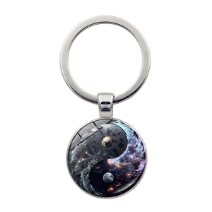 Macro detail of cosmic galaxy Yin Yang symbol keychain with polished silver alloy frame