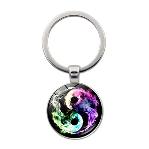 Detailed close-up of rainbow smoke yin yang glass cabochon pendant on a metal keychain
