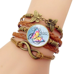 Detail eines Vintage-Mehrschicht-Lederarmbands mit Bronze-Schmetterlingen und Unendlichkeitssymbol