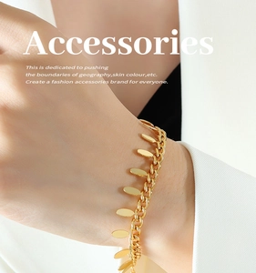 Close-up of 18k gold-plated chain bracelet with leaf tassels on a model's wrist