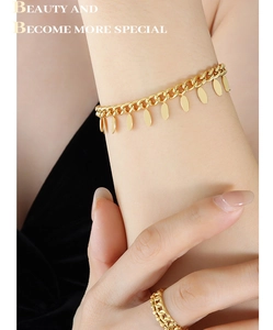 Close-up of golden Cuban chain bracelet with polished oval charms and matching ring set