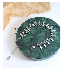 Detailed view of silver chain bracelet with oval sequins on green marble tray