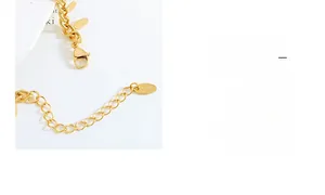 Detailed macro view of gold chain bracelet with leaf pendants and 18K stamp on the clasp