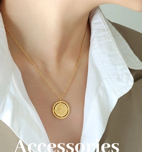 Gros plan d'un pendentif rose vintage doré sur une chaîne en acier inoxydable pour femme