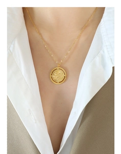 Gros plan du pendentif rose vintage doré poli sur une chaîne délicate pour femme