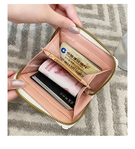Dettaglio degli scomparti interni per carte e della tasca con zip di un portafoglio bianco