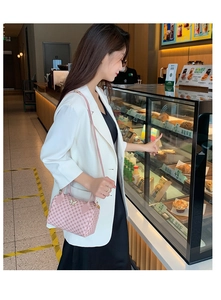 Schicke rosa Boston Bag mit Kreismuster und Schmetterlingsanhänger in Lifestyle-Szene