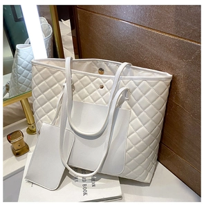 White quilted tote bag set with a small matching pouch on a stylish dressing table