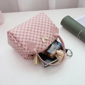 Rosa Boston Bag mit Schmetterlingsdekor und Kleemuster, zeigt geräumige Kapazität