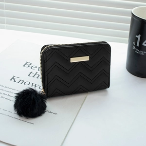 Petit portefeuille noir matelassé avec détails dorés et pompon en fausse fourrure