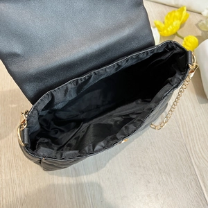 Detail view of the black quilted crossbody bag showing its spacious inner compartment